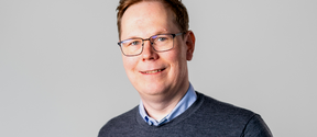 Portrait of Kimmo Järvinen, from the Xiphera team. A man smiling at the camera